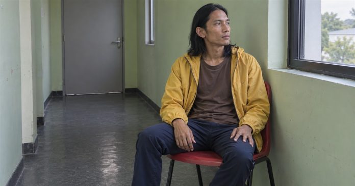 Learn to Protect Yourself as an Empath — realistic corridor break cover 20261004 Man in a yellow jacket seated on a red chair beside a window in a quiet corridor