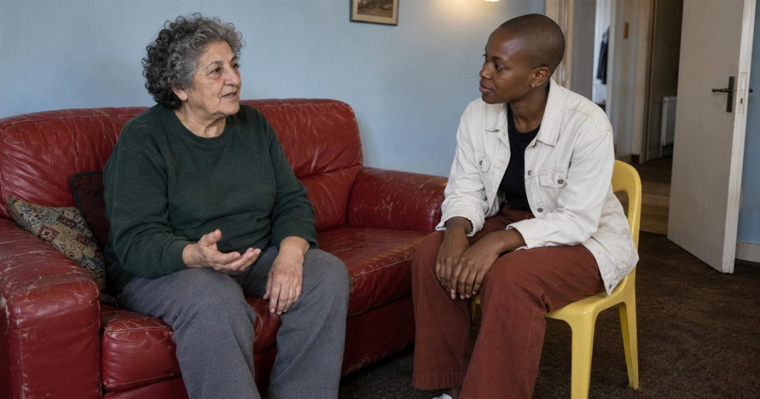 Personal boundaries supportive conversation realistic cover 3586 Two women talking attentively in a blue-walled room, seated on a red sofa and yellow chair