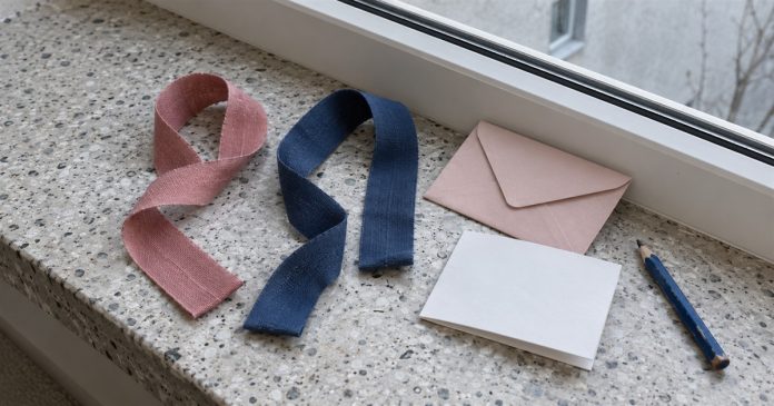 Love practice realistic ribbon reflection 3724 Separate rose and navy ribbons beside a pink envelope, blank note and blue pencil on a terrazzo windowsill.