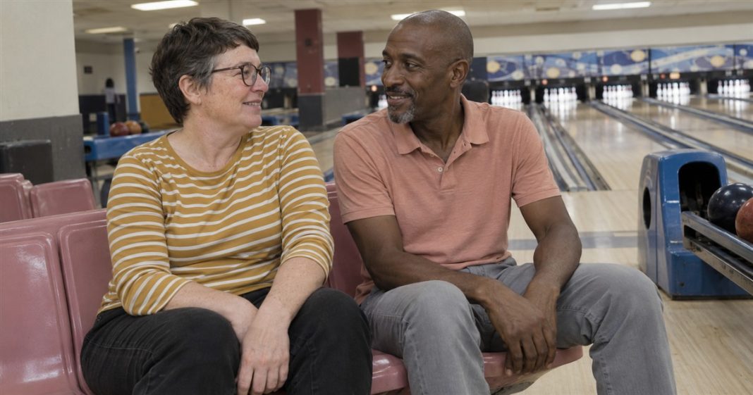 Soulmate realistic bowling conversation 3743 Two adults smiling at each other on pink seats beside bowling lanes.