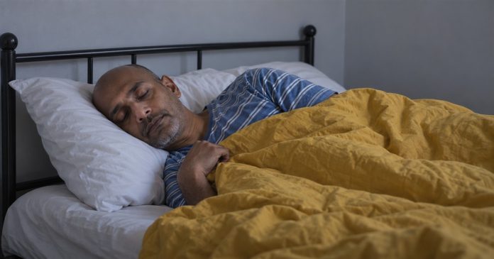 Psychic888 realistic ordinary bedtime rest 3827 Man resting on his side with a white pillow and mustard-yellow duvet in a plain bedroom.
