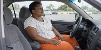 Woman taking a quiet pause in the driver's seat of a parked car.