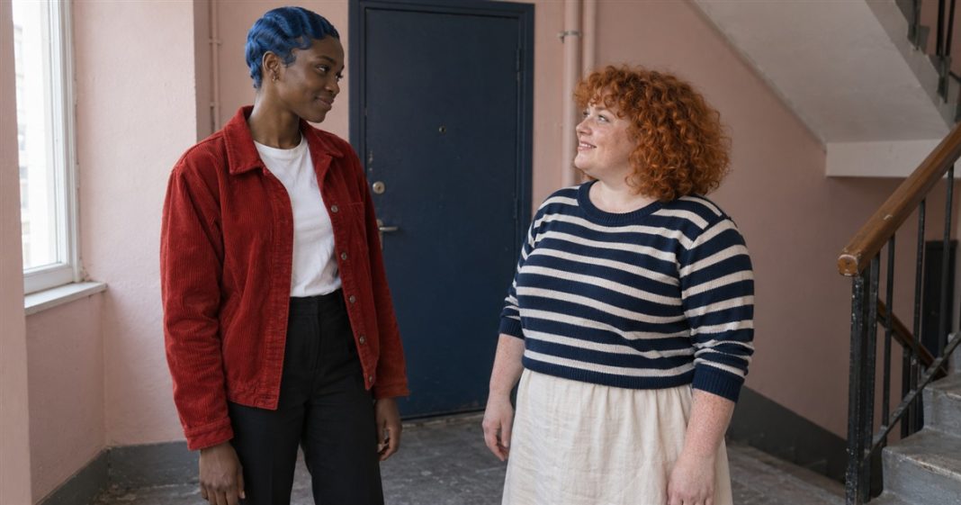 Psychic888 realistic landing conversation 3863 Two women having a warm conversation on an apartment landing beside a blue door.